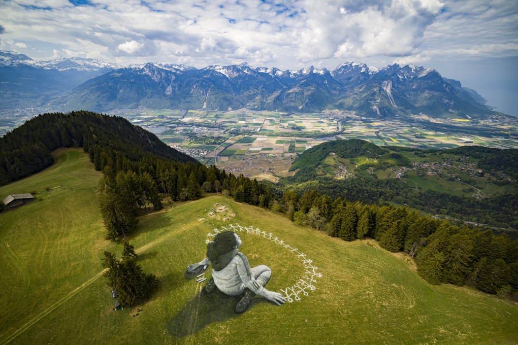 An aerial view of a biodegradable giant land art painting, “Beyond Crisis”, by Swiss-French artist Saype in the alpine resort of Leysin, Switzerland. Photo: EPA-EFE