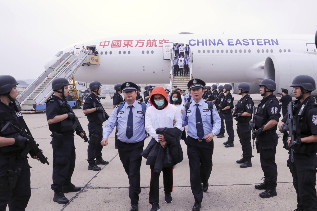 Police escort Taiwanese suspects from a plane at Beijing Capital International Airport after their deportation from Spain in 2019. Photo: Xinhua