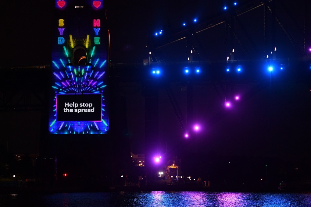 The Sydney Harbour Bridge pylon is lit with a Covid-19 safety message ahead of New Year’s Eve fireworks in Sydney. Photo: DPA