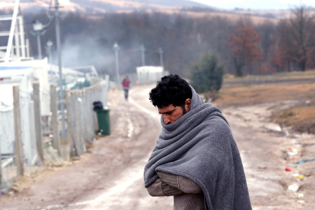 A migrant tries to warm himself at the Lipa camp in Bihac, Bosnia and Herzegovina, on Friday. Some thousand refugees at the camp were scheduled to be relocated from the camp on Thursday after a fire burned down most of the camp on December 23, but they were returned to Lipa camp. Photo: EPA-EFE