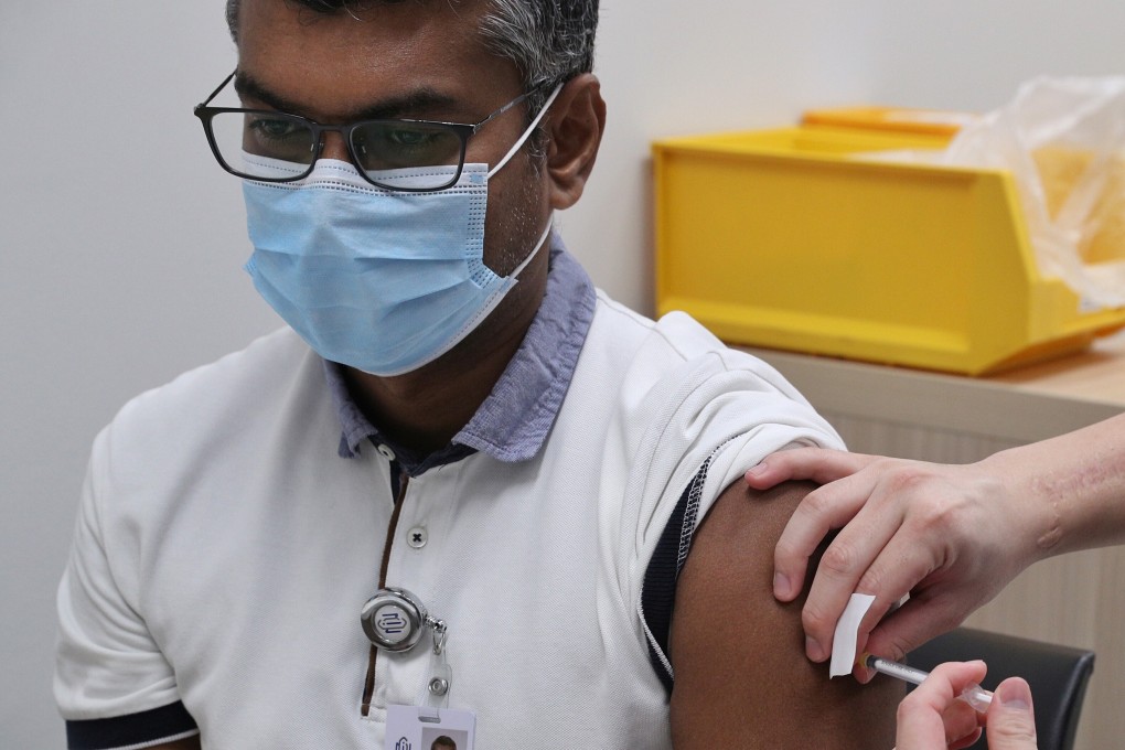 A health care worker receives a dose of the coronavirus vaccine at the National Centre for Infectious Diseases in Singapore. Photo: Reuters