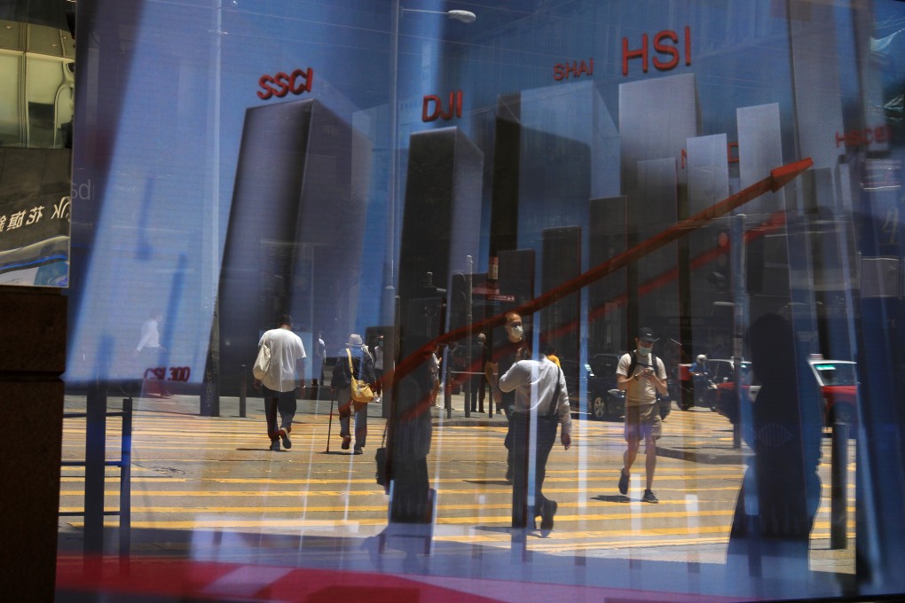 Reflection of pedestrians on an electronic board showing the Hang Seng Index in Central. Hong Kong and China stocks advanced on first day of 2021. Photo: May Tse