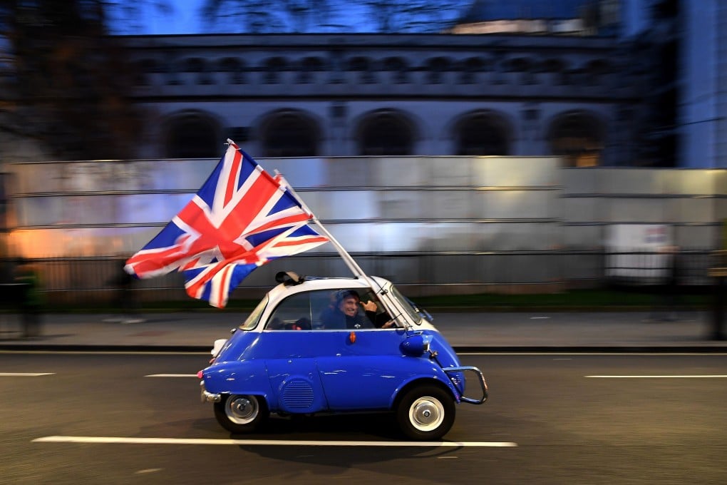 A man waves Union flags as he drives past Brexit supporters in Parliament Square in London on January 31. Photo: AFP