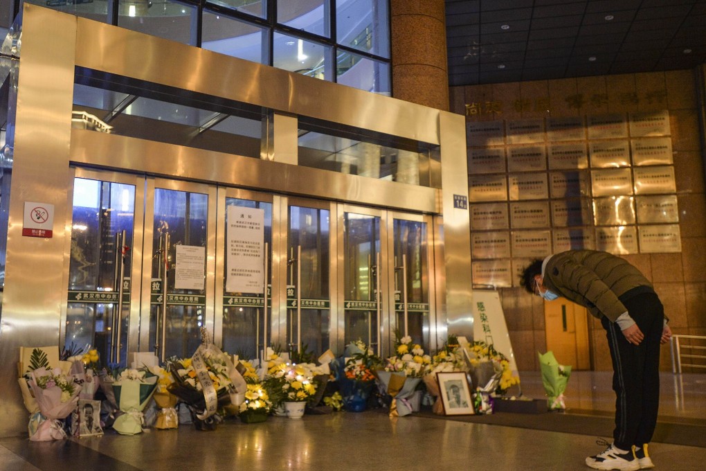 A visitor pays tribute to Dr Li Wenliang at Li’s hospital in Wuhan, in central China’s Hubei province, on February 7 last year. Li, 34,﻿ died earlier that day after contracting the novel coronavirus while treating patients. Photo: TNS