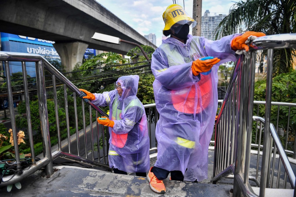 Cleaners from the Bangkok Metropolitan Authority disinfect the railings of a pedestrian bridge in the Thai capital on Wednesday. Photo: AFP