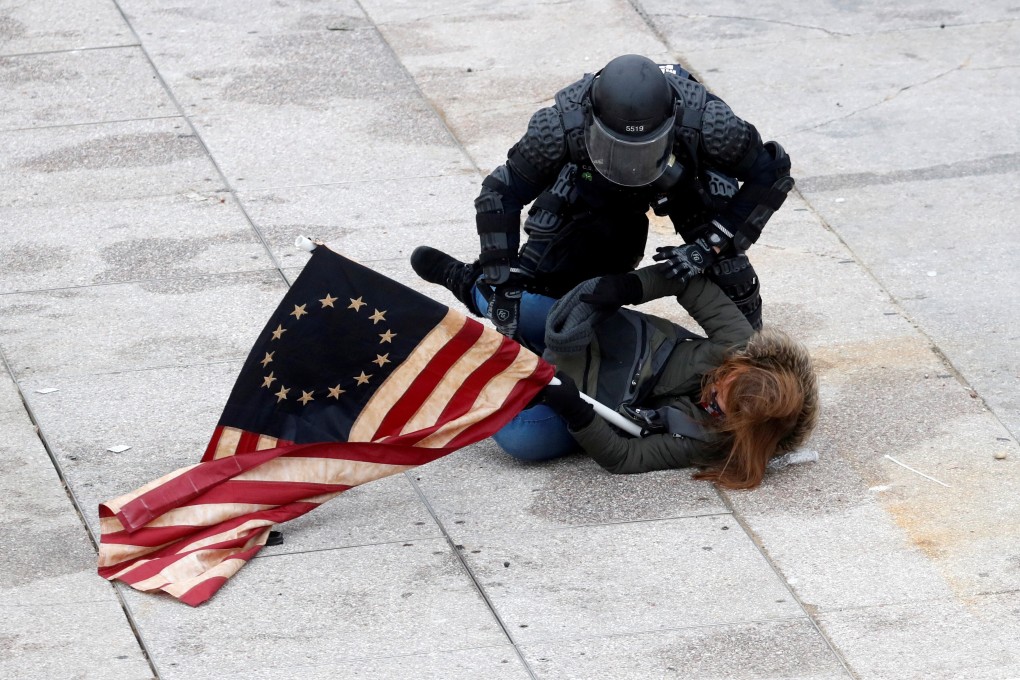 A police officer detains a pro-Trump protester as crowds storm the US Capitol. Photo: Reuters