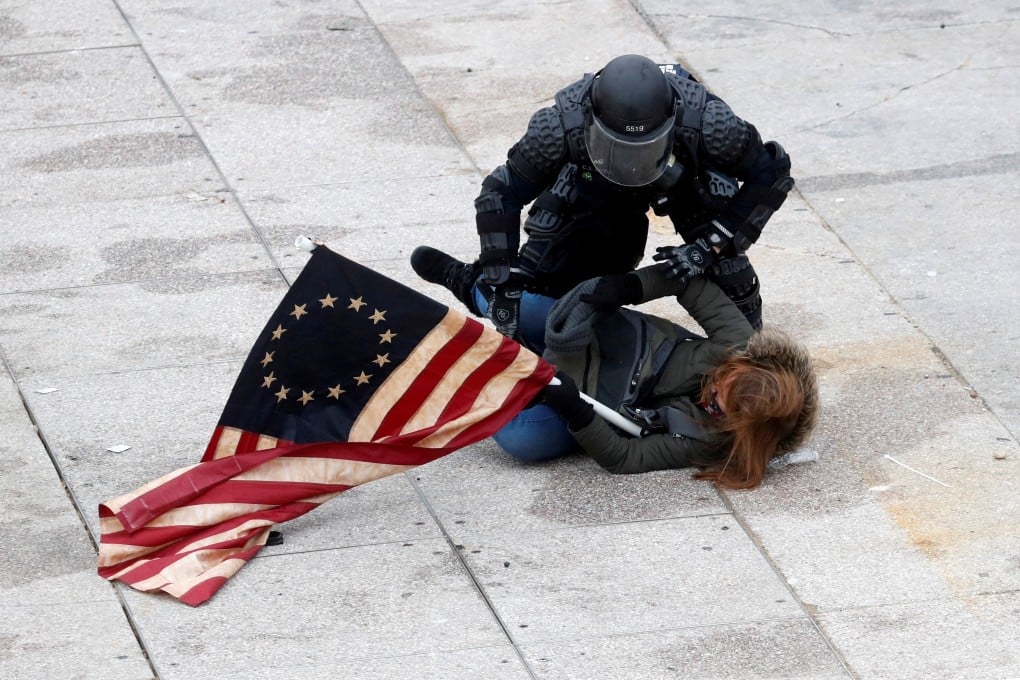 A police officer detains a pro-Trump protester as crowds storm the US Capitol. Photo: Reuters