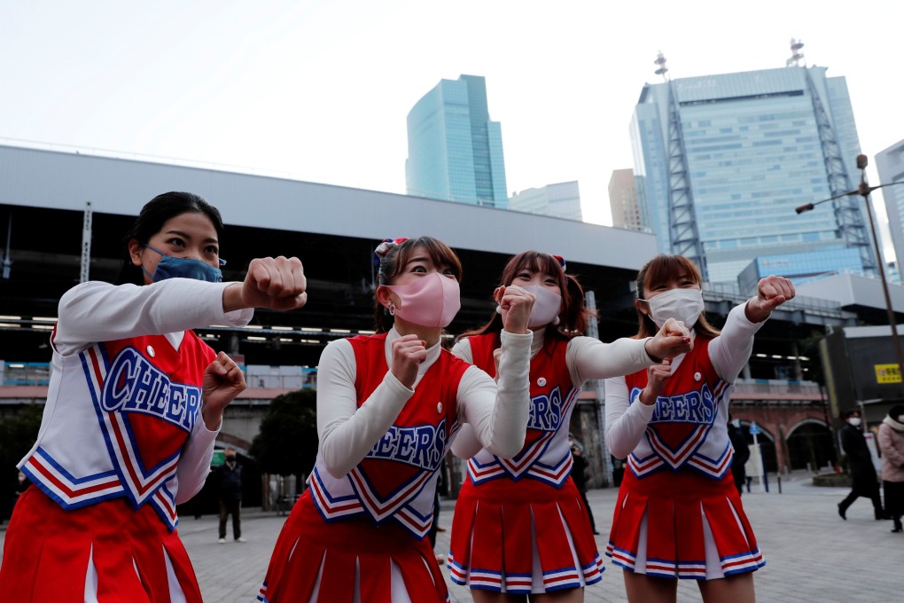 Cheerleaders perform in front of Shimbashi Station during the rush-hour in Tokyo on Thursday. Photo: Reuters