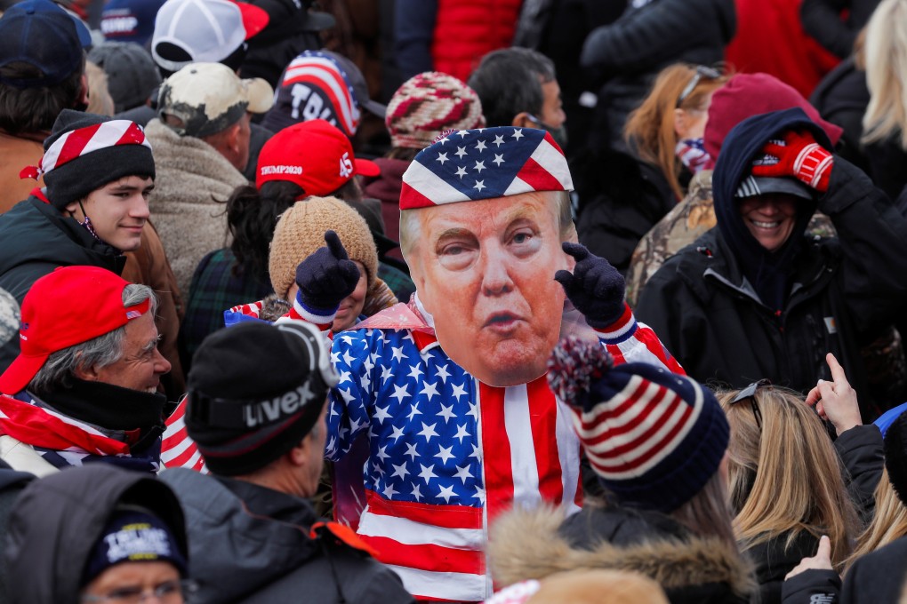 A person in a Donald Trump mask gestures as the US president’s supporters gather in Washington on Wednesday. Photo: Reuters