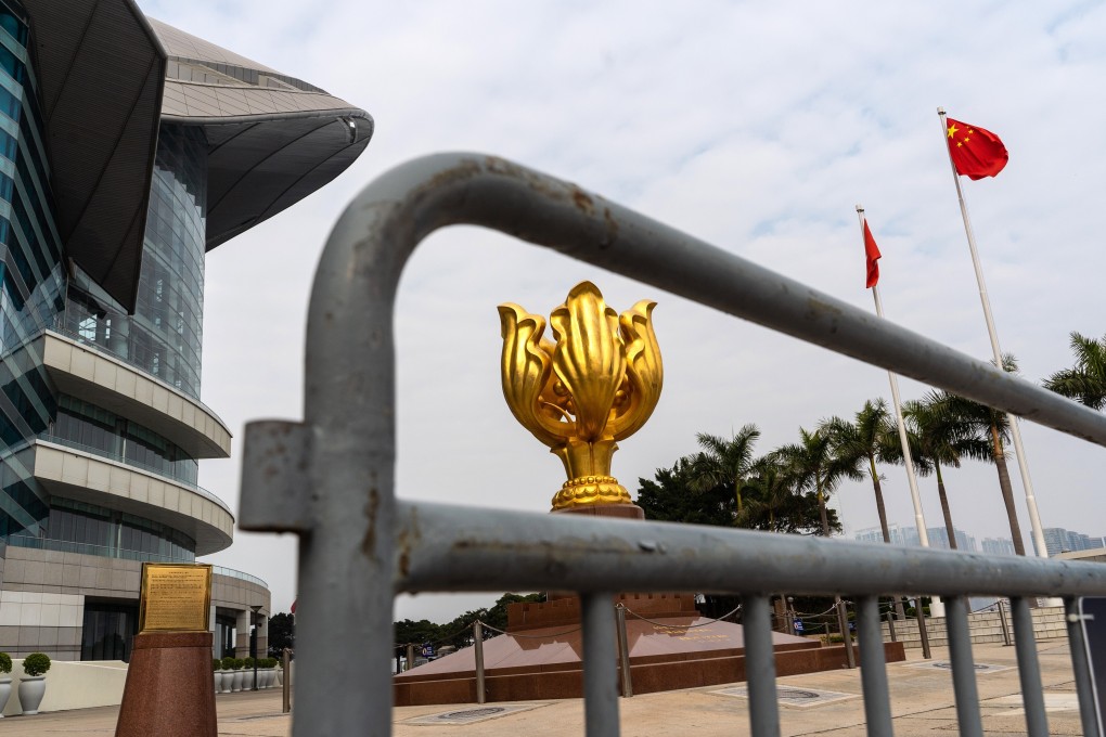 The statue of a golden Bauhinia blakeana, the symbol of Hong Kong, is seen behind a barricade while the city and national flags fly in the distance at the Golden Bauhinia Square in Wan Chai on January 7. Photo: Bloomberg