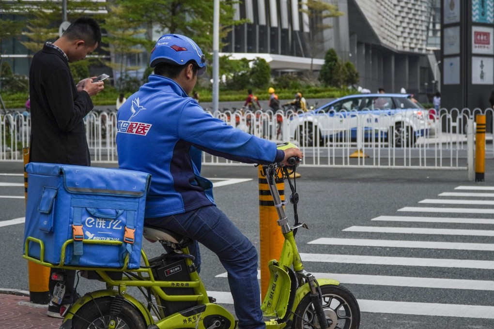 An Ele.me delivery driver waits at a pedestrian crossing in the Futian district of Shenzhen. Photo: SCMP / Roy Issa