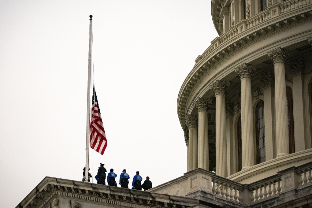 Members of the US Capitol Police lower the flag at the Capitol in Washington on Friday. House Speaker Nancy Pelosi ordered flags at the Capitol to fly at half-staff after the death of Capitol Police Officer Brian Sicknick, who was fatally injured during Wednesday’s violence. Photo: Bloomberg