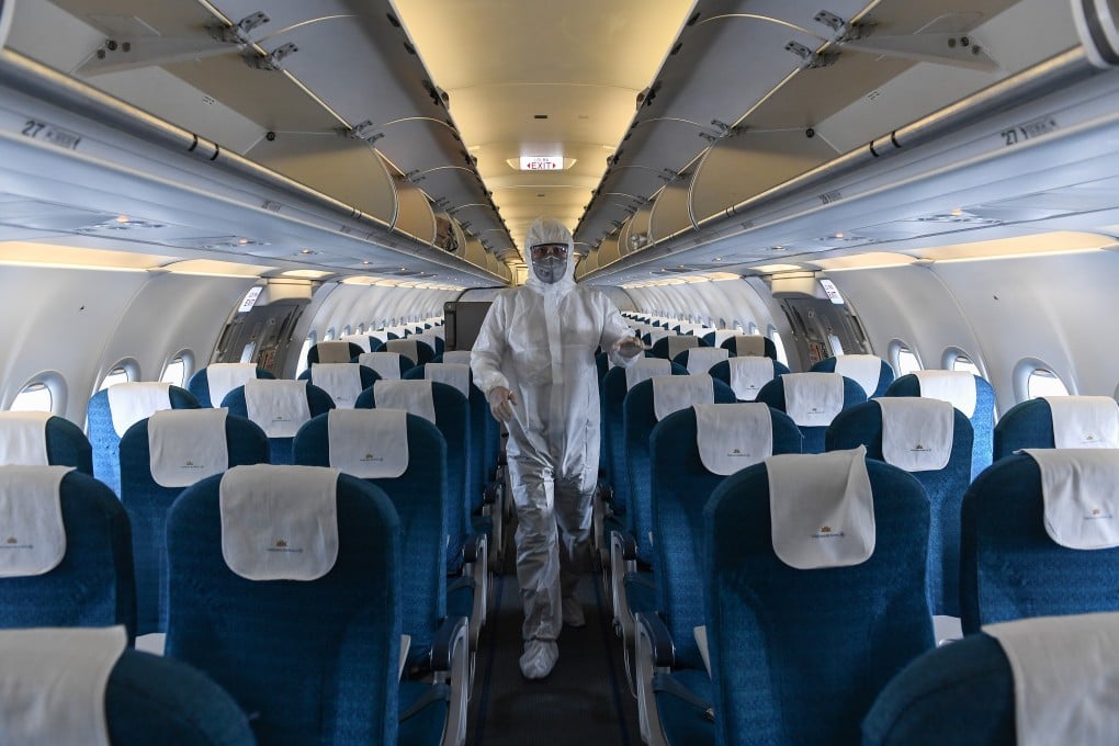 A worker wearing a protective suit disinfects a Vietnam Airlines at Noi Bai International Airport in Hanoi. Photo: AFP