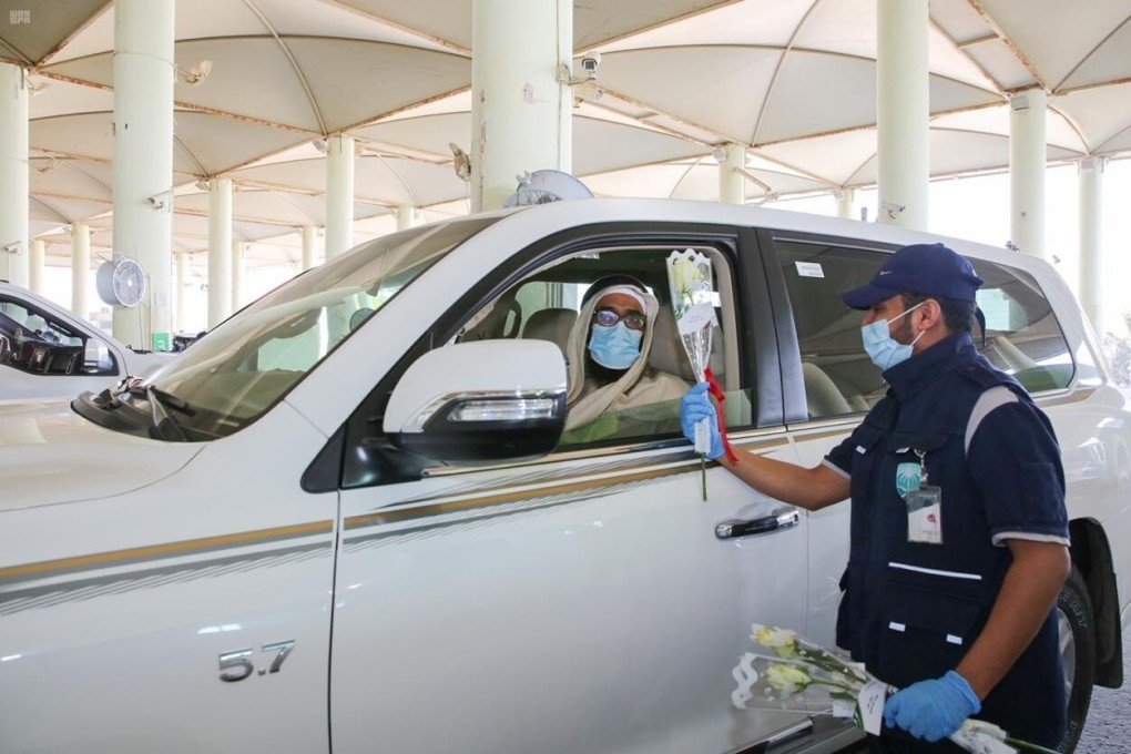 An officer gives flowers to a driver at a border crossing of Saudi Arabia with Qatar, after the two countries restored ties and opened borders on Saturday. Photo: Saudi Press Agency / Handout via Reuters