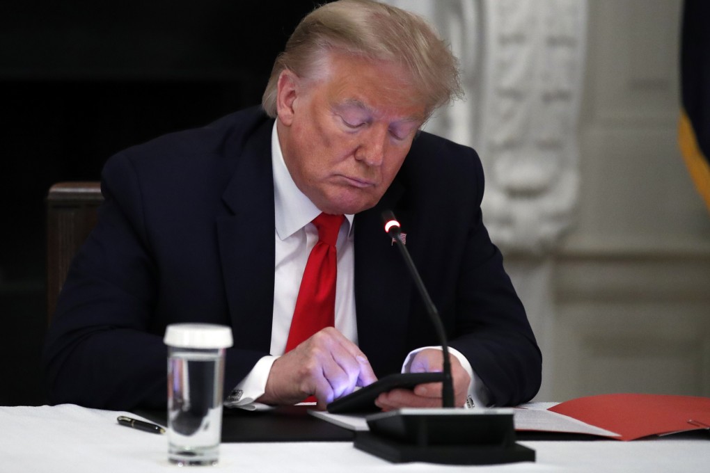 US President Donald Trump looks at his phone. Moves by big tech companies to restrict his accounts come after years of efforts by both Democrats and Republicans in Washington to cut Silicon Valley down to size. Photo: AP