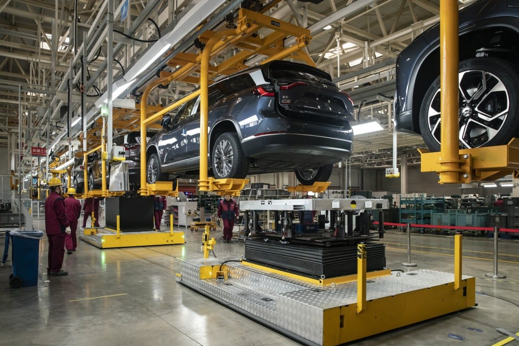 Employees install batteries onto an electric sport utility vehicle (SUV) during a media tour of the Nio production facility in Hefei, Anhui province, in December 2020. Photo: Bloomberg