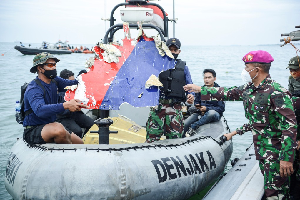 Indonesian Navy personnel transport debris believed to be from the Sriwijaya Air SJ-182 jet. Photo: Antara Foto via Reuters