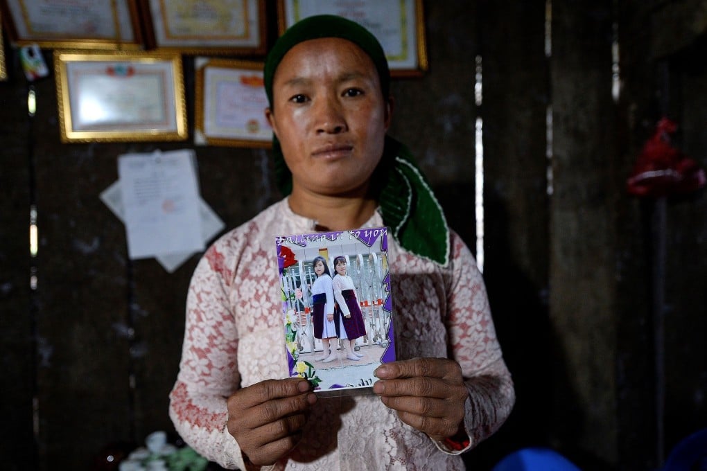 Vu Thi Dinh, a Vietnamese mother, poses with a photograph of her missing teenage daughter Dua and her best friend, at her house in Meo Vac, a mountainous border district between Vietnam’s Ha Giang province and China, on October 27, 2018. Both girls are feared to have been sold as child brides. Photo: AFP