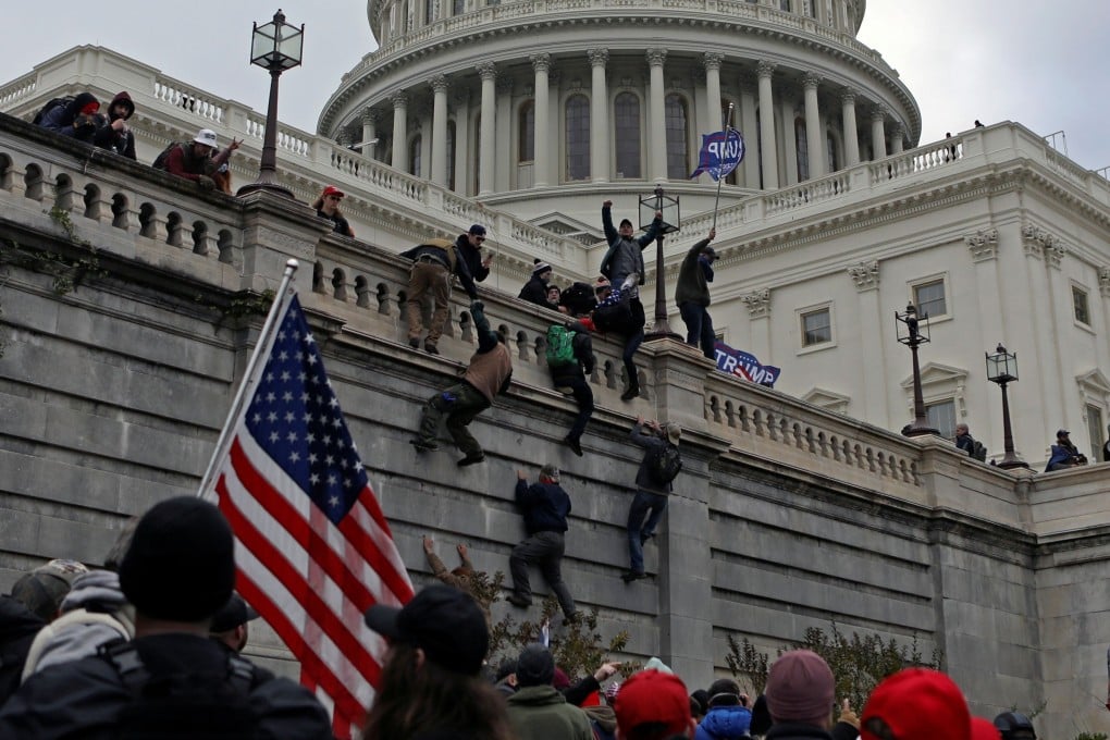 Supporters of President Donald Trump climb a wall at the US Capitol during a protest against certification of the election results by Congress on January 6. Beijing has seized on the chaos to criticise Washington. Photo: Reuters