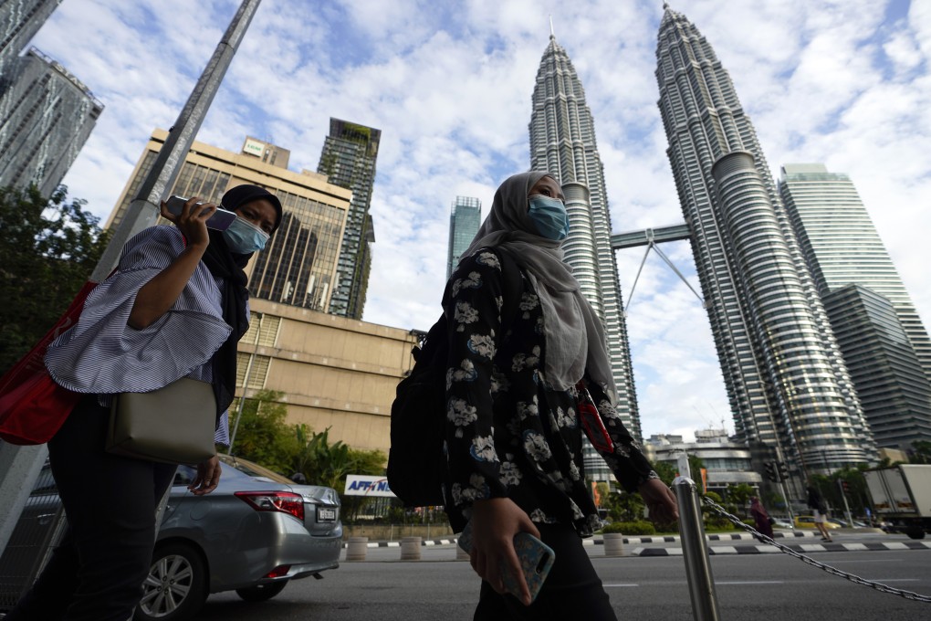 People clad in face masks seen in downtown Kuala Lumpur. Photo: AP