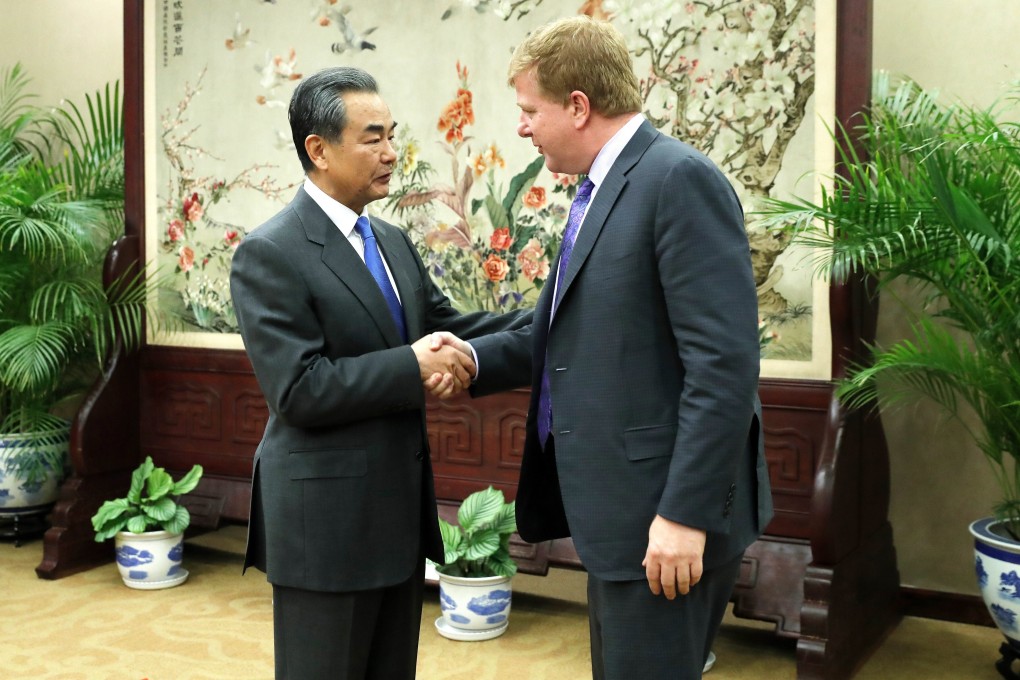 Chinese Foreign Minister Wang Yi shakes hands with Myron Brilliant, head of International Affairs at the US Chamber of Commerce, ahead a meeting in Beijing in February 2019. Photo: EPA-EFE