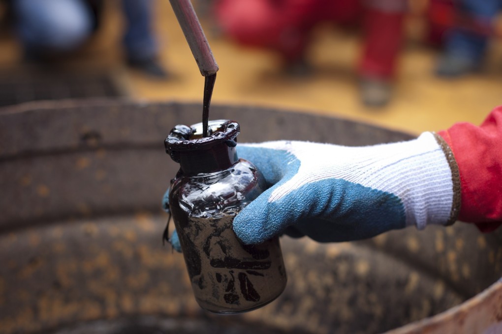 A worker collects a crude oil sample at an oil well in Venezuela. Photo: Reuters