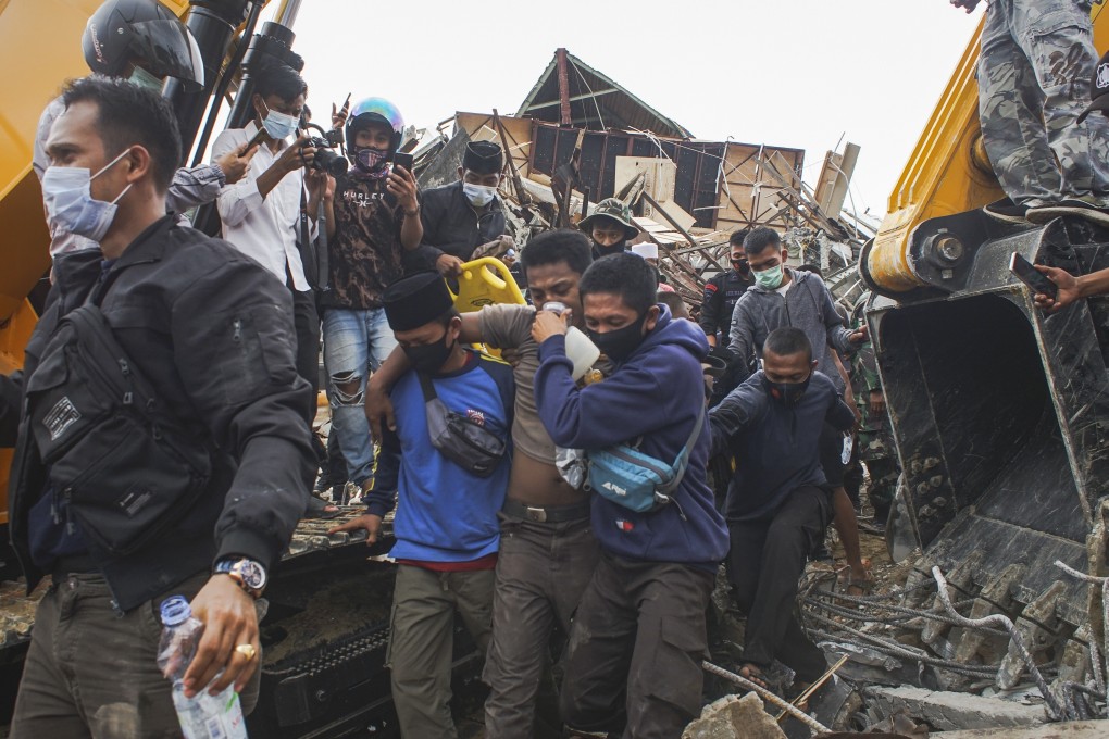 Rescuers evacuate a quake survivor pulled out from the ruin of a collapsed building in Mamuju, Indonesia. Photo: EPA-EFE