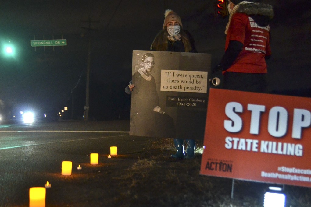 An anti-death penalty activist holds a sign along Prairieton Road across from the Federal Death Chamber in Terre Haute, Indiana. Photo: The Tribune-Star via AP