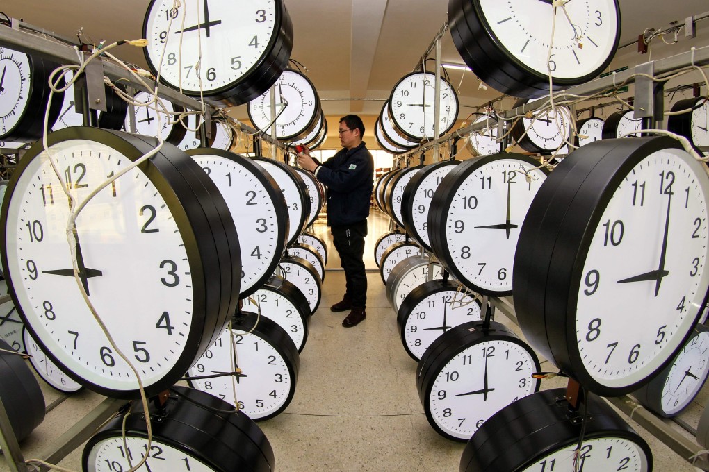 A technician checks hanging clocks at a workshop of a clock company in Yantai, in eastern China’s Shandong province, on December 15. Photo: AFP