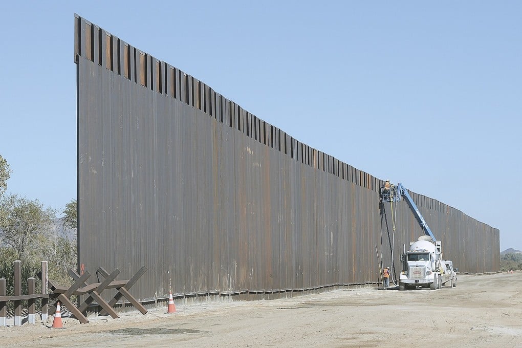 Workers assemble the new bollard wall along the US-Mexico border on the Colorado River near Yuma, Arizona on November 1, 2019. For Trump and his supporters, that wall remains at the very heart of his immigration policy and his legacy. Photo: AP