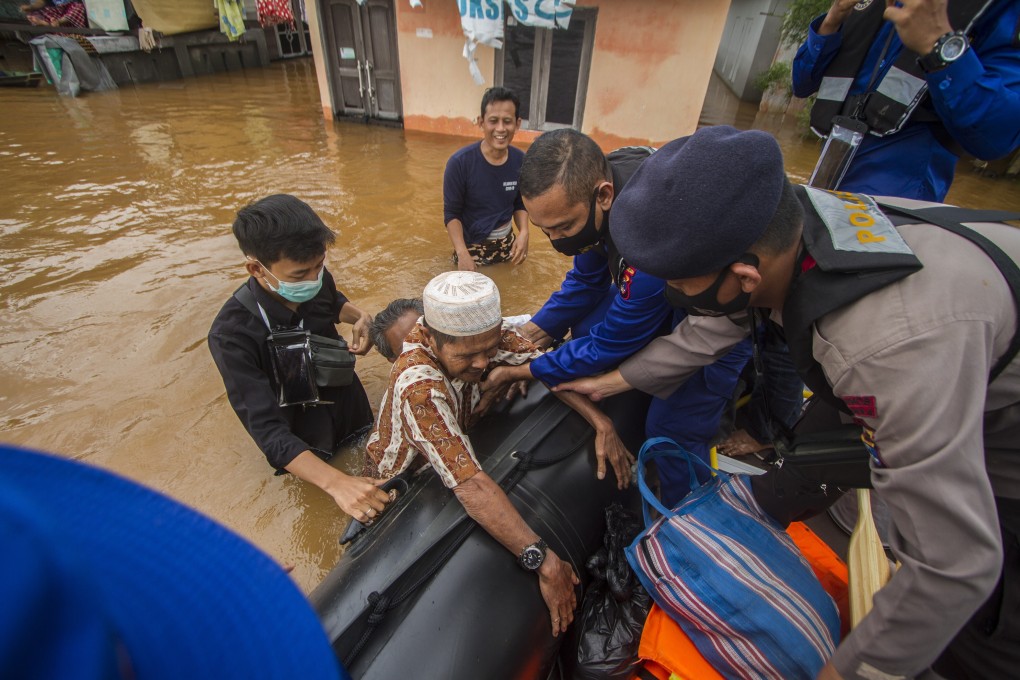 Rescuers assist an elderly man onto their boat in Banjarmasin, South Kalimantan. Photo: AP