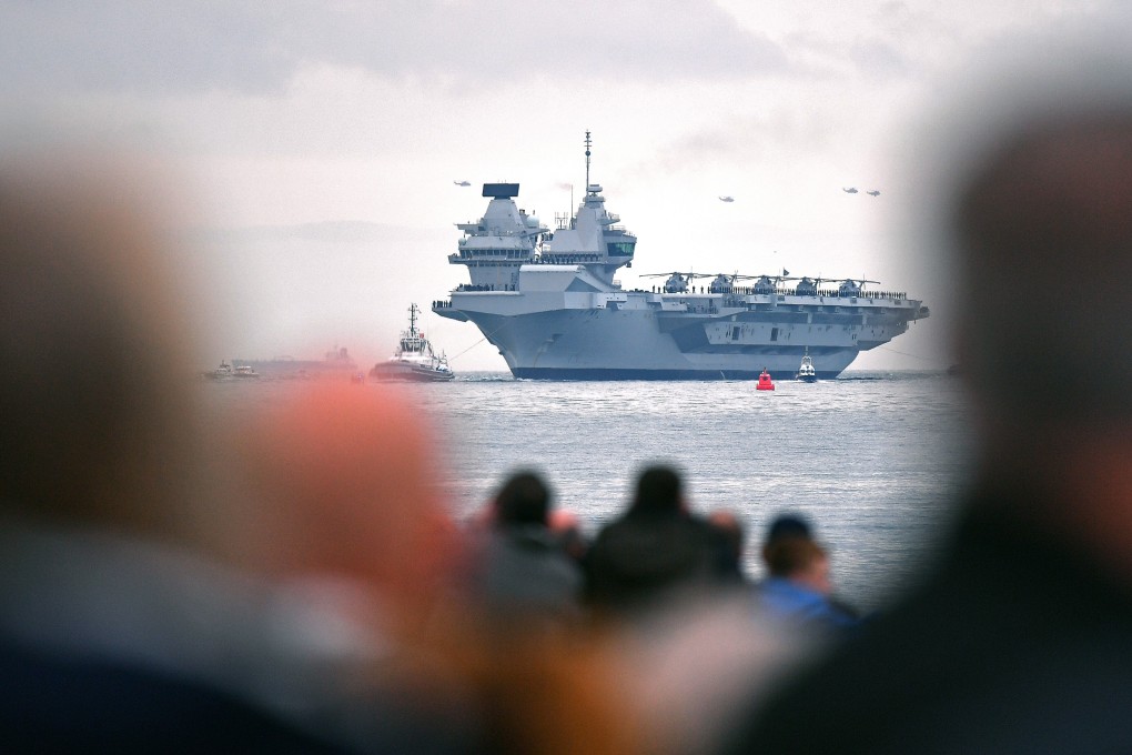 The 65,000-ton British aircraft carrier HMS Queen Elizabeth gets an assist from a tugboat into Portsmouth Harbou, southern England. Photo: AFP