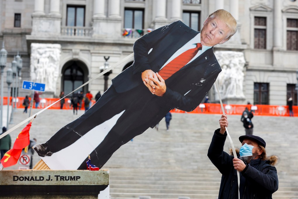 An anti-Trump protester pulls a cardboard cut-out depicting US President Donald Trump outside the Pennsylvania State Capitol in Harrisburg, Pennsylvania. Photo: Reuters