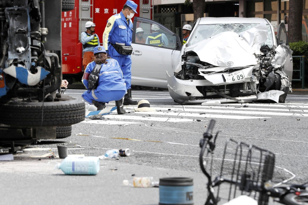 Police officers inspect the scene of a car accident in 2019 in which an elderly driver smashed into pedestrians at a Tokyo intersection, killing a woman and a girl on a bicycle and overturning a garbage truck. Photo: Kyodo