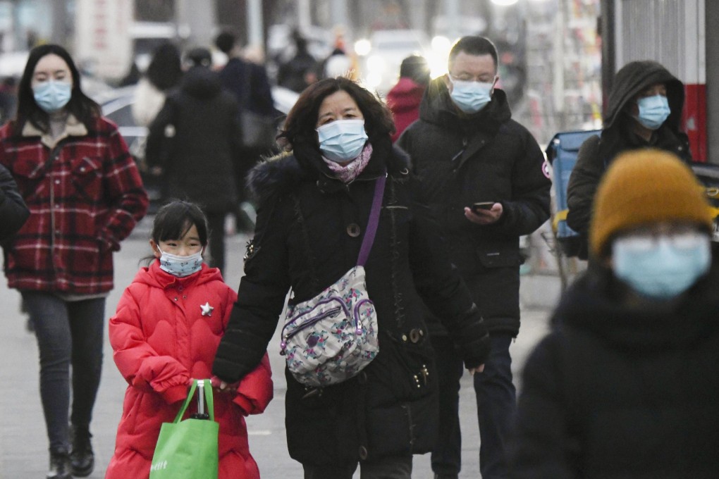 People wearing face masks walk in Beijing on Wednesday. Photo: Kyodo