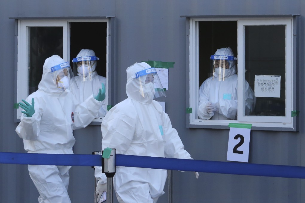 Medical workers pass by their colleagues in a booth as they wait for people to come for tests at a coronavirus testing site in Seoul, South Korea, as new cases reached a two-month low. Photo: AP