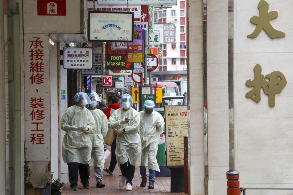 Home Affairs Department staff distribute notices to residents in Jordan on January 21 to undergo mandatory Covid-19 testing following an outbreak in the community. Photo: K.Y. Cheng