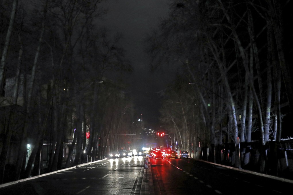 Cars drive on an unlit street during a blackout in Tehran on January 20. Photo: AP
