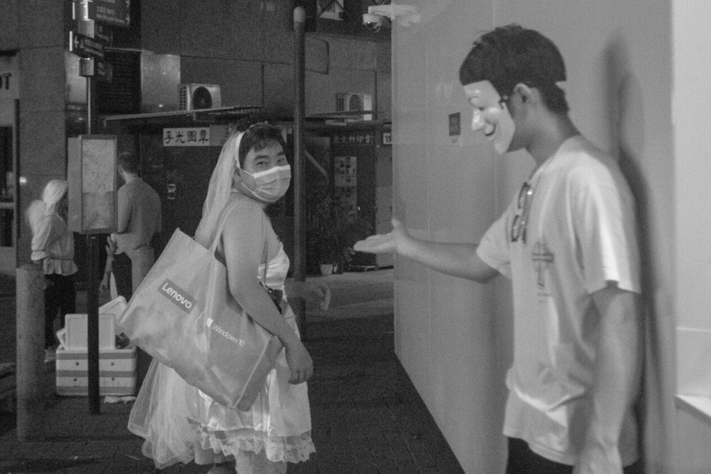 A masked protester holds his hand out towards someone who appears to be in drag in Nelson Tang’s ‘Where Are You Going, Where Have You Been’ (2019-20), taken during the 2019 anti-government protests and part of the ‘Unruly Visions’ show. Photo: Nelson Tang Chak-man