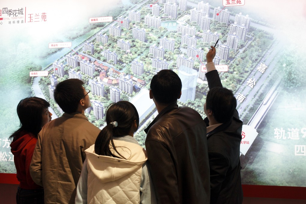 An agent shows two couples the layout of a new residential development at a real estate fair in Shanghai. The city is cracking down on fake divorces, used by couples to get first-time buyer privileges and acquire more property. Photo: Getty Images