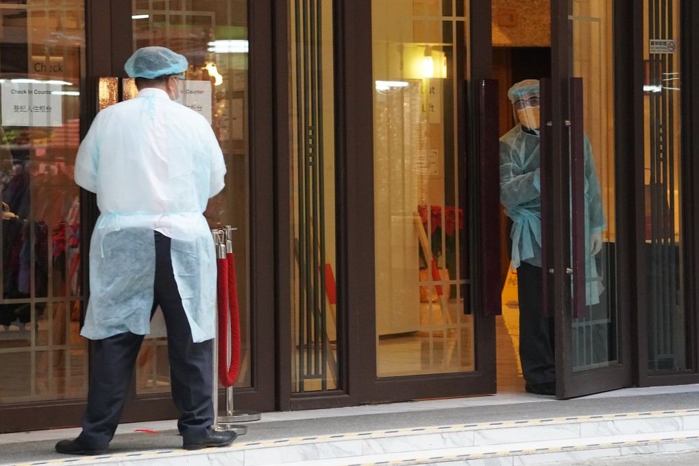 Hotel staff wearing full protective gear in North Point, Hong Kong, wait for travellers from Britain, on December 22. Photo: Felix Wong