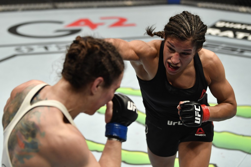 Julianna Pena punches Sara McMann in their bantamweight fight at UFC 257. Photos: Jeff Bottari/Zuffa LLC