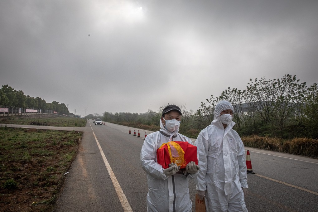 A man carries the ashes of a deceased relative near a funeral home in Wuhan in April. There has been concern that deaths related to Covid-19 have been under-reported. Photo: EPA-EFE