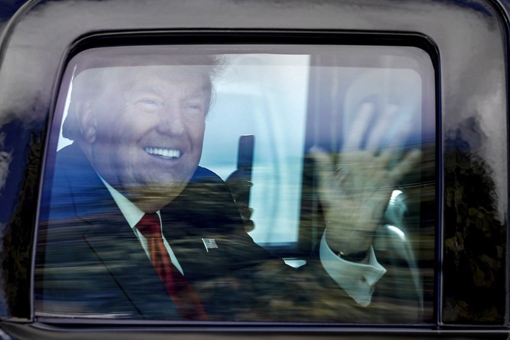 Former president Donald Trump waves to supporters as his motorcade drives through West Palm Beach, Florida. File photo: AP