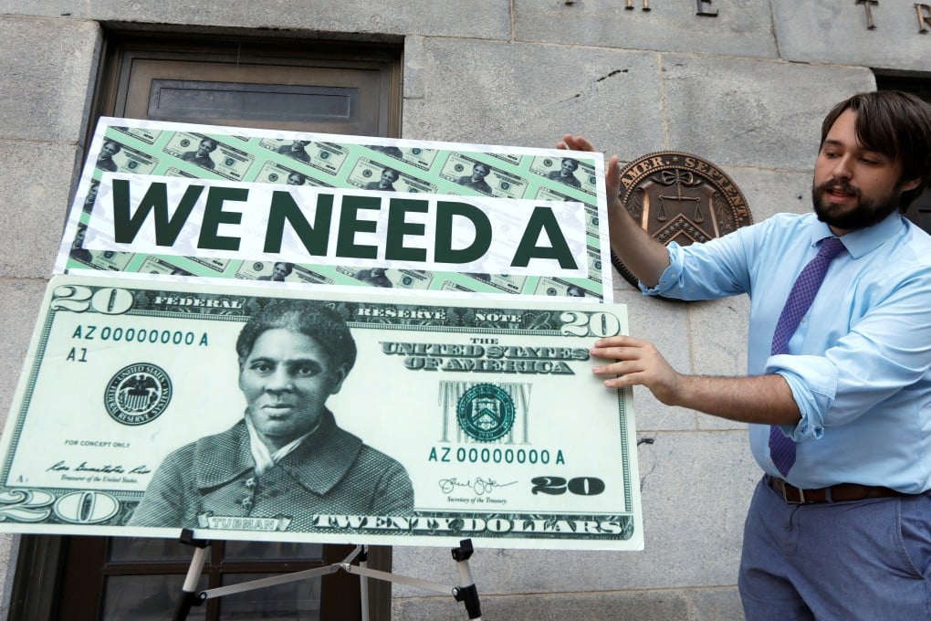 A Capitol Hill staff member places signs on the steps of the US Treasury Department before a news conference in June 2019 on the decision to indefinitely delay putting famous abolitionist Harriet Tubman on the new US$20 bill. Photo: Reuters