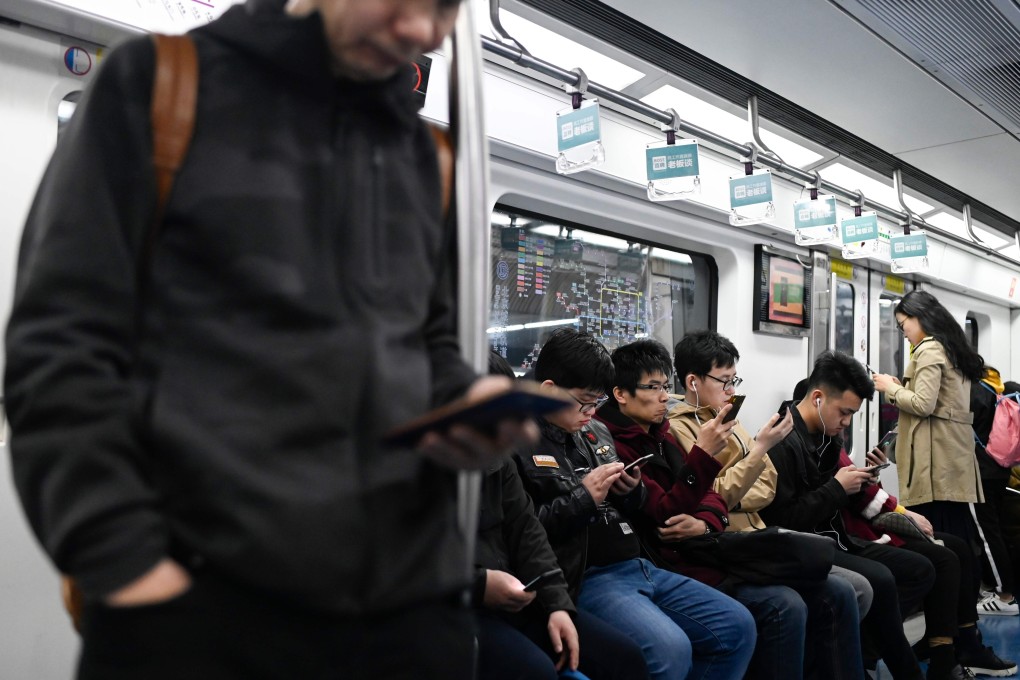 Commuters use their phones on a subway in Beijing on April 8, 2019. Photo: AFP
