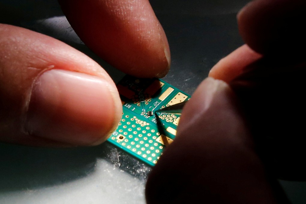 A researcher plants a semiconductor on an interface board during research work. Photo: Reuters