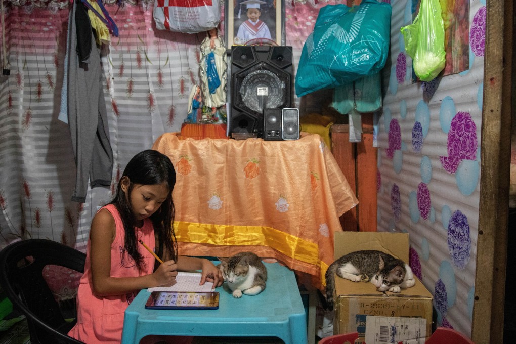 An 8-year-old Filipino girl works on an assignment at her home in Manila earlier this month, as schools remain closed amid the pandemic. Photo: Reuters