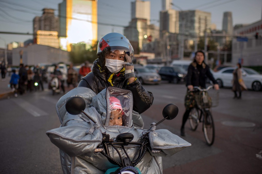 A woman and her daughter ride an electric bike during rush hour in Beijing on October 21. China’s economy grew 2.3 per cent last year, but new clusters of Covid-19 cases have raised questions about the outlook for this year. Photo: AFP