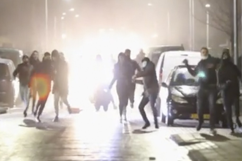 Rioters throw stones at police, in Haarlem, in the Netherlands, on Monday. Photo: AP
